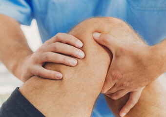 orthopedic doctor examining bent knee